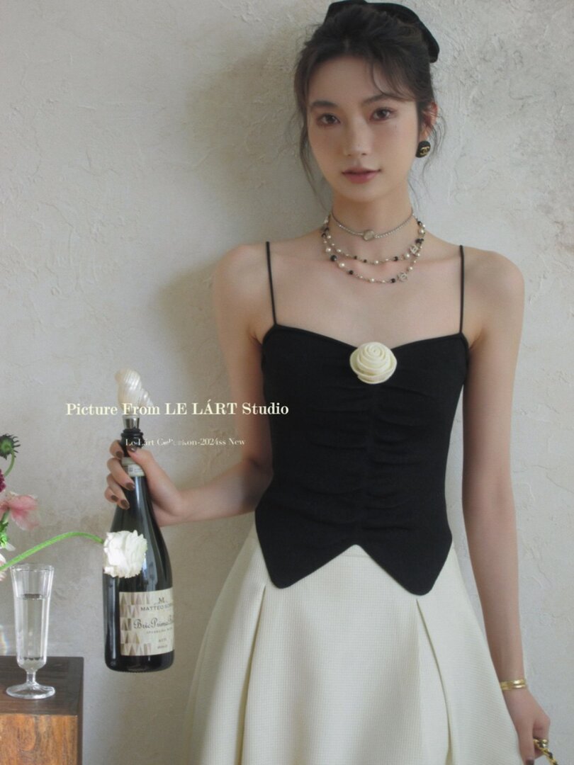 Model wearing a black-and-cream strappy dress with floral detail