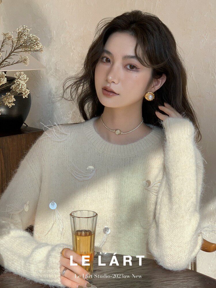 Woman wearing a cream fuzzy sweater with decorative buttons