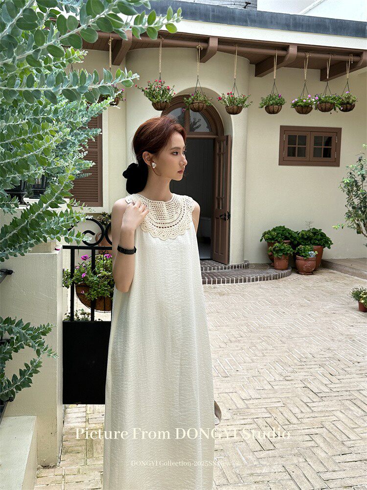 Woman wearing a sleeveless cream maxi dress outdoors