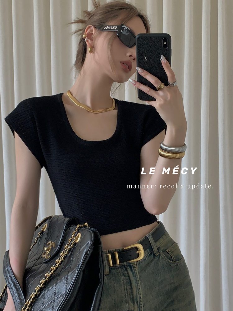 Black fitted knit crop top worn by a model with jeans and accessories