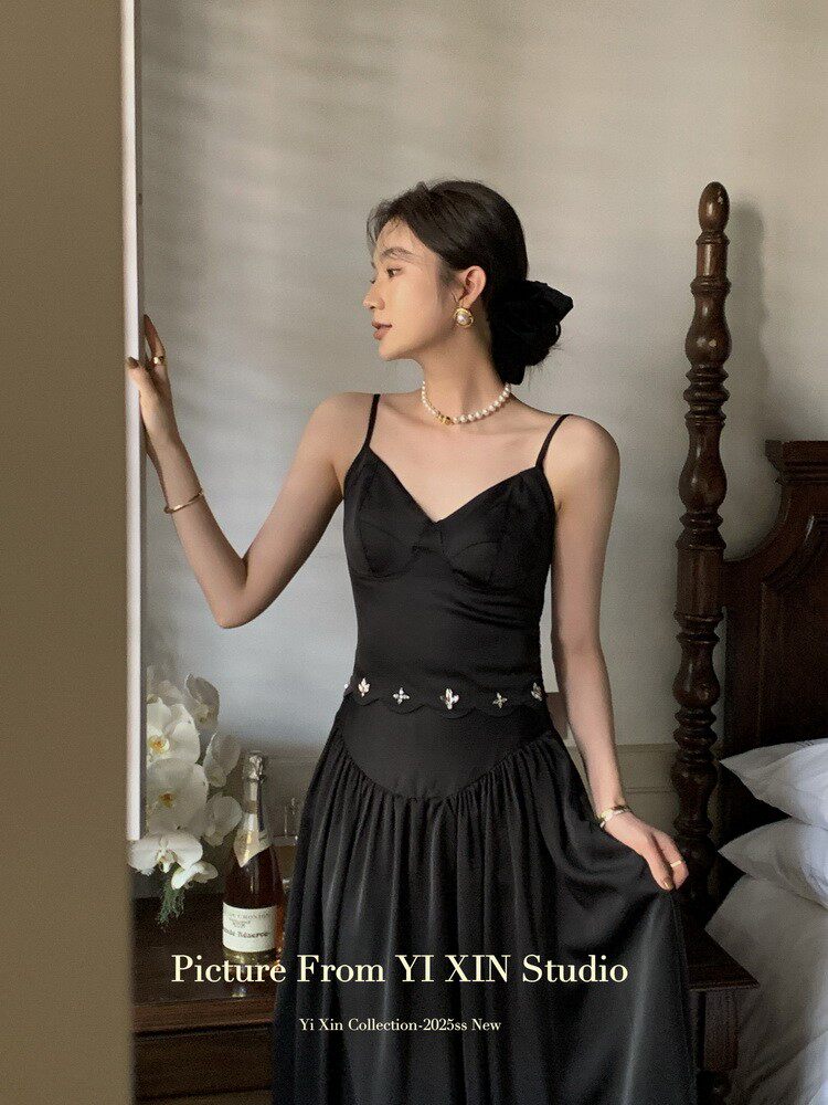 Black spaghetti-strap satin dress worn by a model