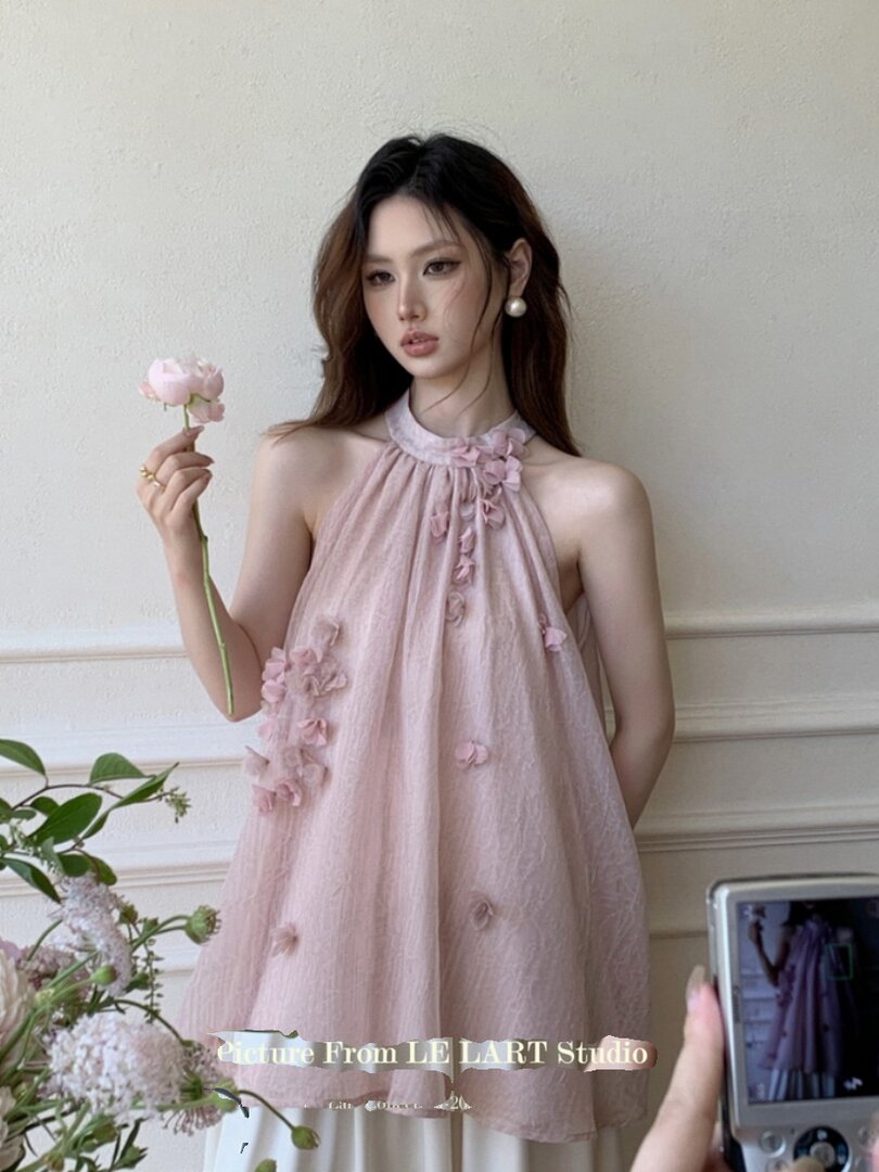 Pink halter mini dress with floral appliqués worn by a model
