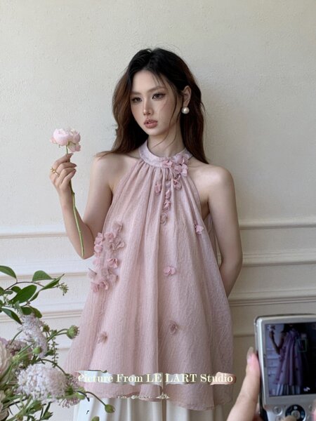 Pink halter mini dress with floral appliqués worn by a model