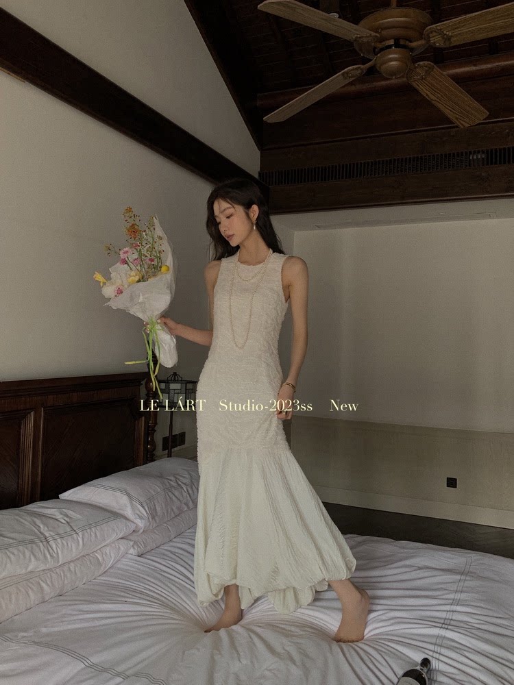 Woman wearing a sleeveless white long dress indoors