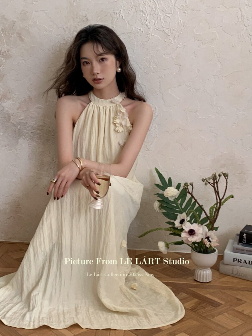 Cream halter maxi dress worn by a model indoors