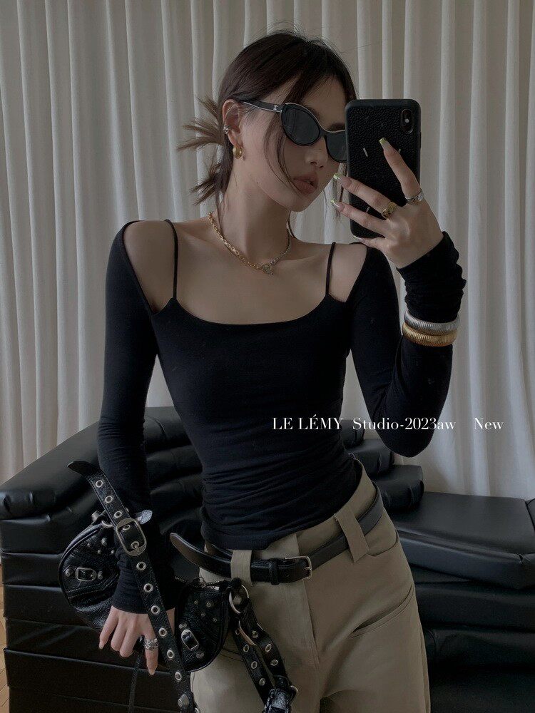Model wearing a black long-sleeve square-neck top with beige trousers and accessories