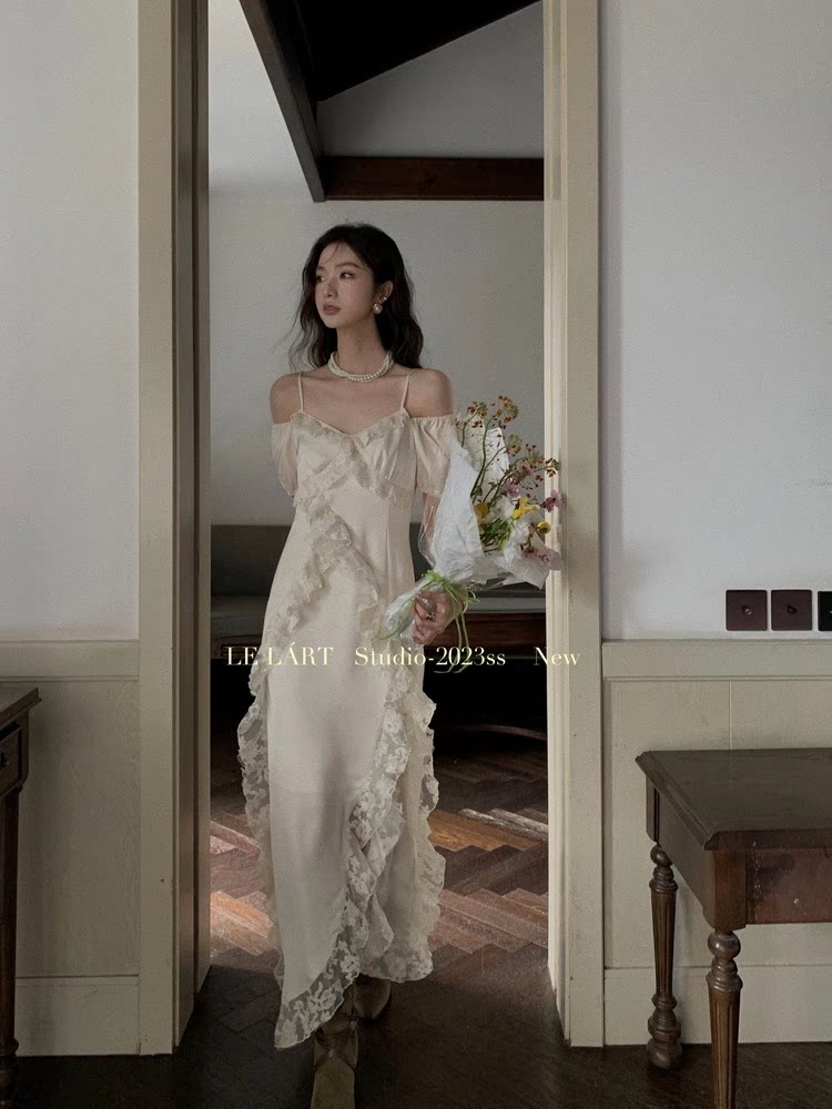 Woman wearing a cream satin lace off-shoulder long dress