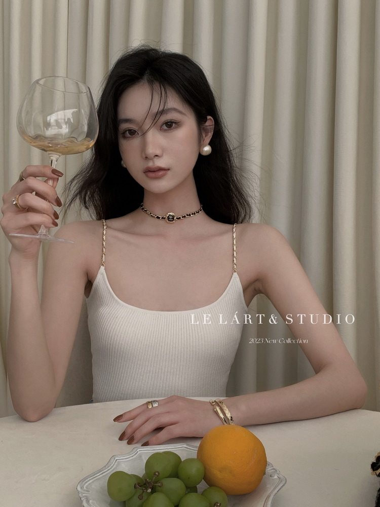 Woman wearing a white ribbed spaghetti-strap camisole top