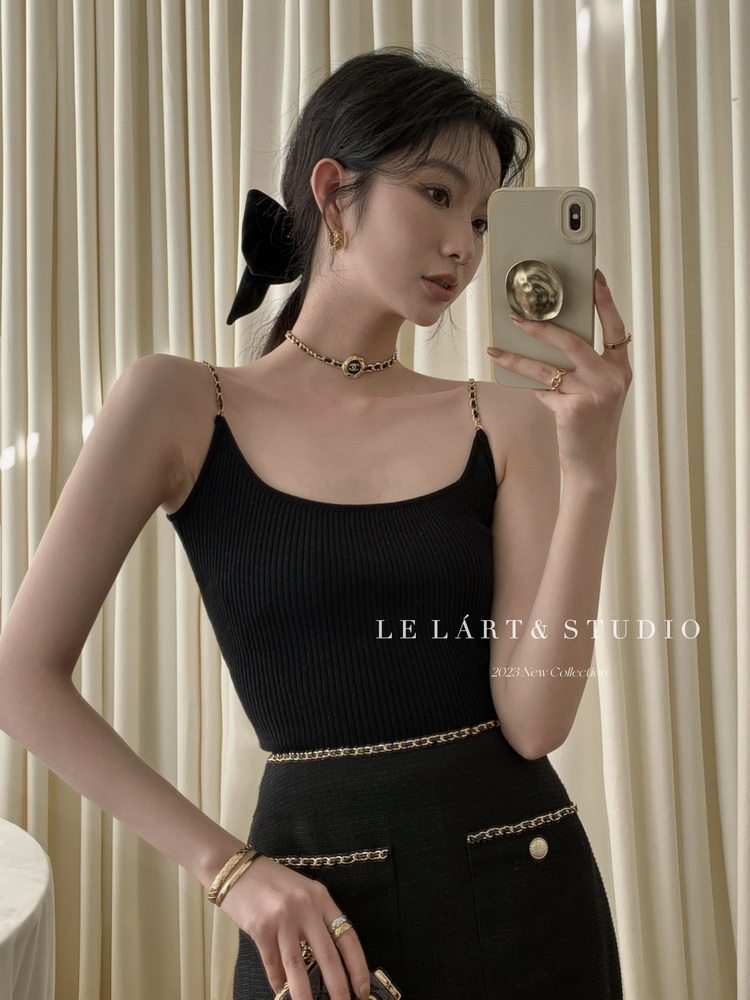 Black fitted ribbed dress worn by a model with gold chain details