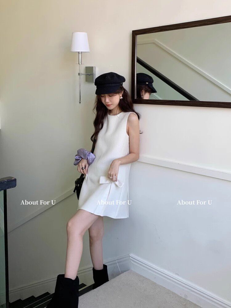 White sleeveless mini dress worn by a model indoors