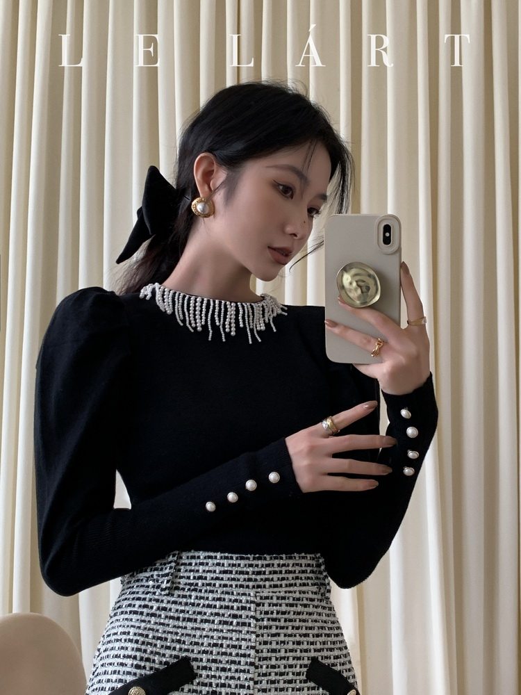 Black embellished long-sleeve top with tweed skirt worn by a model