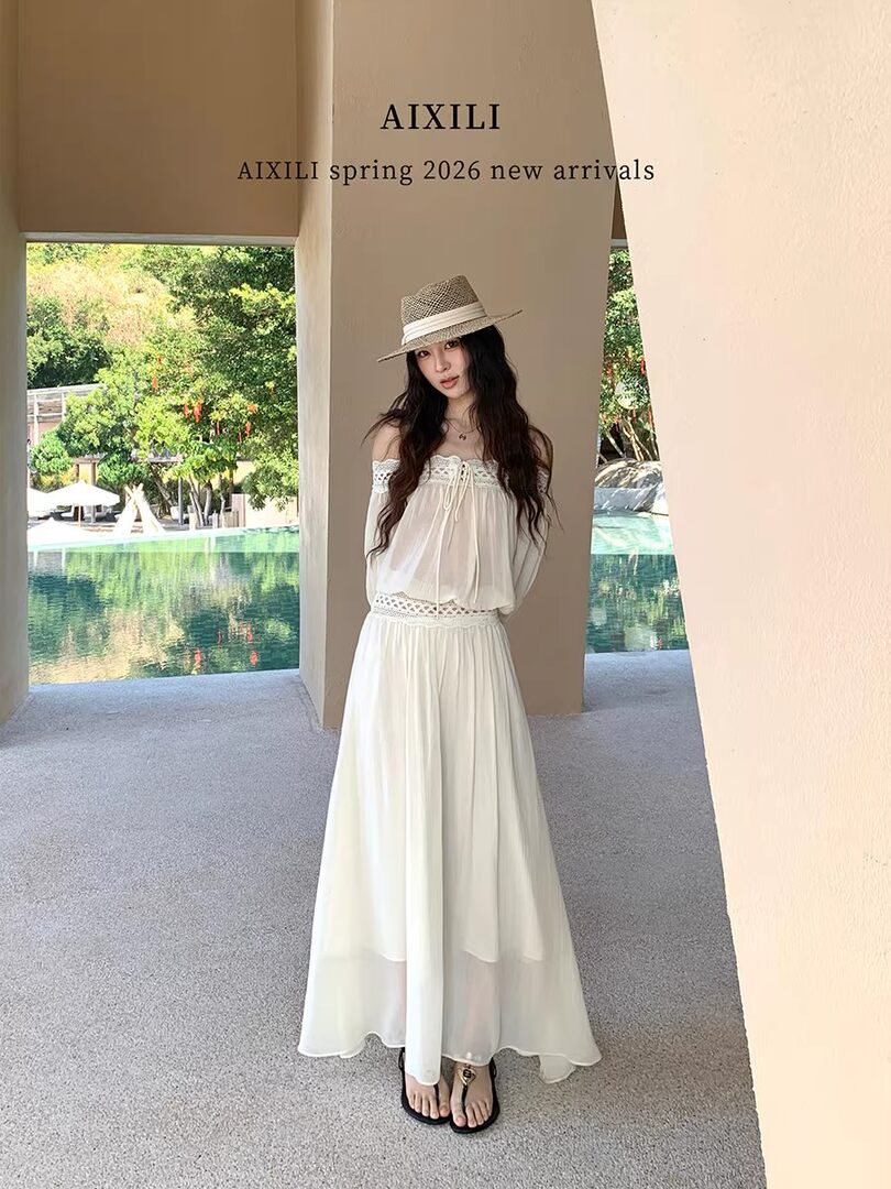 Model wearing a white off-shoulder maxi dress and straw hat by a poolside