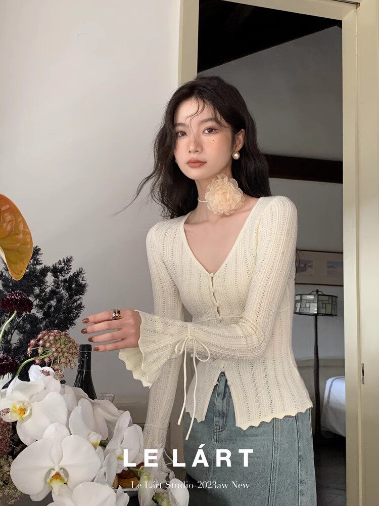 Cream knit long-sleeve tie-front sweater worn by a model