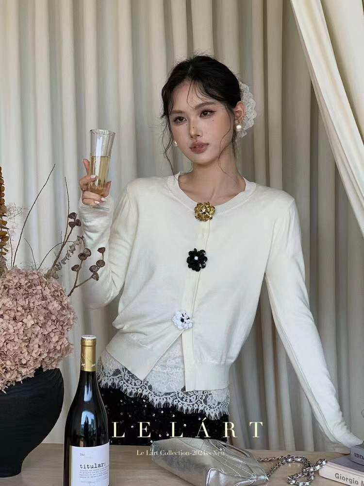 White long-sleeve cardigan with lace trim worn by a model
