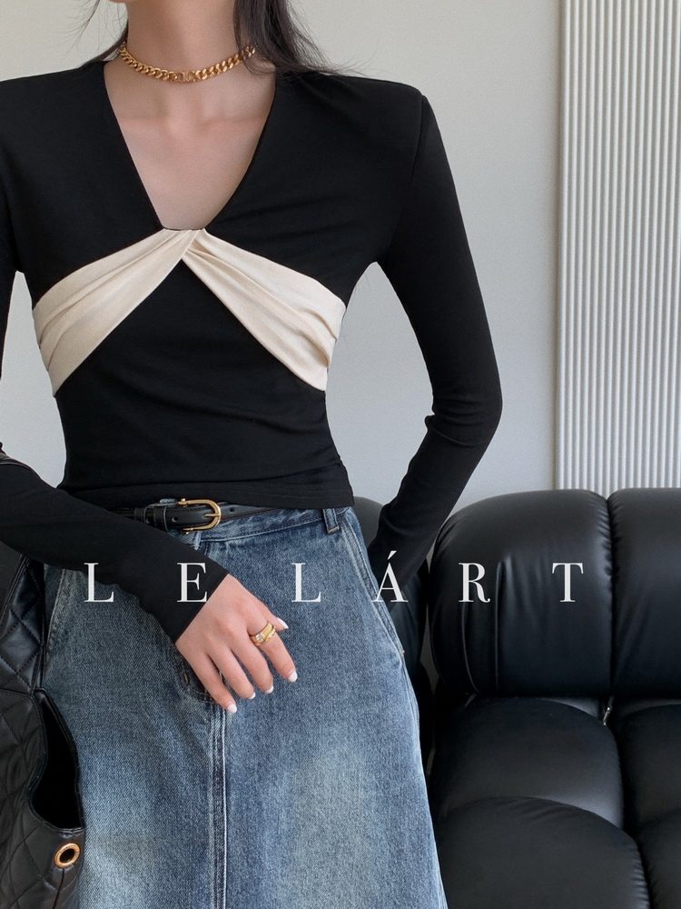 Model wearing a black and cream long-sleeve top with a denim skirt