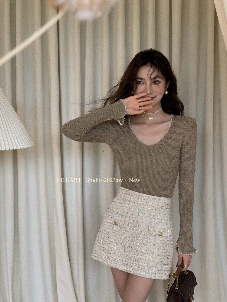 Woman modeling a ribbed long-sleeve top with a tweed mini skirt