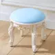 Низкий круглый табурет, окрашенный в золотой цвет, из светло-голубой кожи.