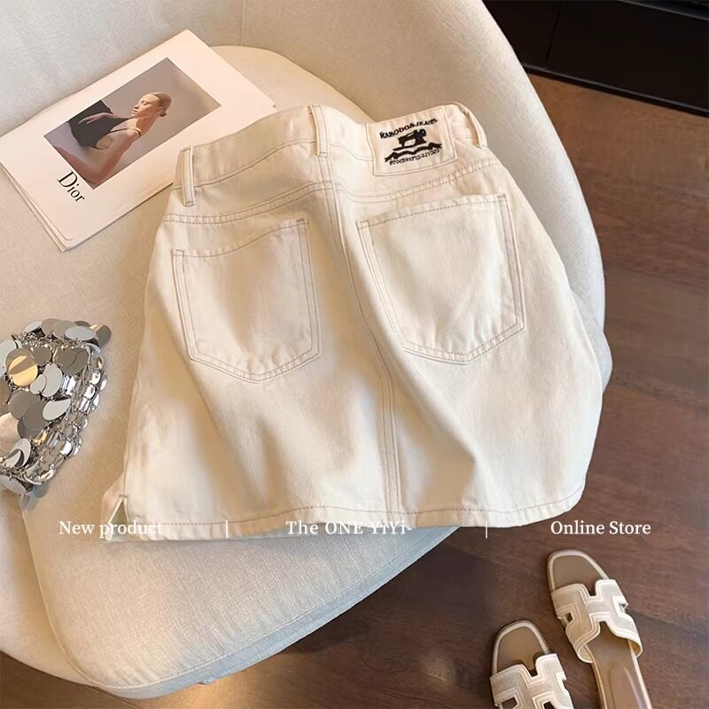 米白色口袋贴布刺绣牛仔半身裙女夏2026新款高腰显瘦开叉a字短裙