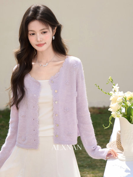 Model wearing a light lavender knit cardigan over a white dress