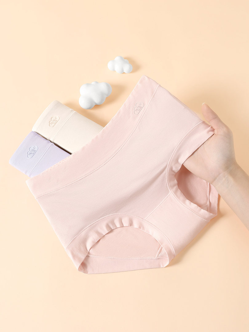 Pastel women’s seamless underwear briefs laid flat on a beige background