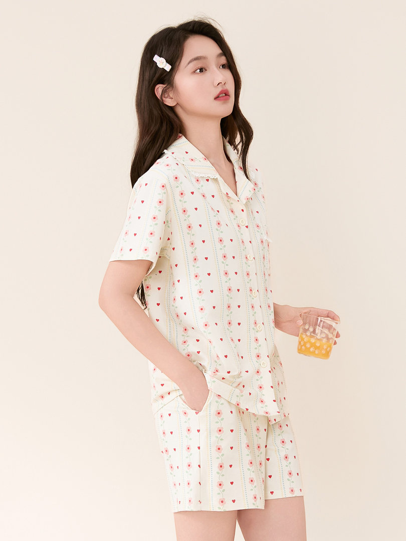 Woman wearing a cream patterned short-sleeve pajama set with shorts