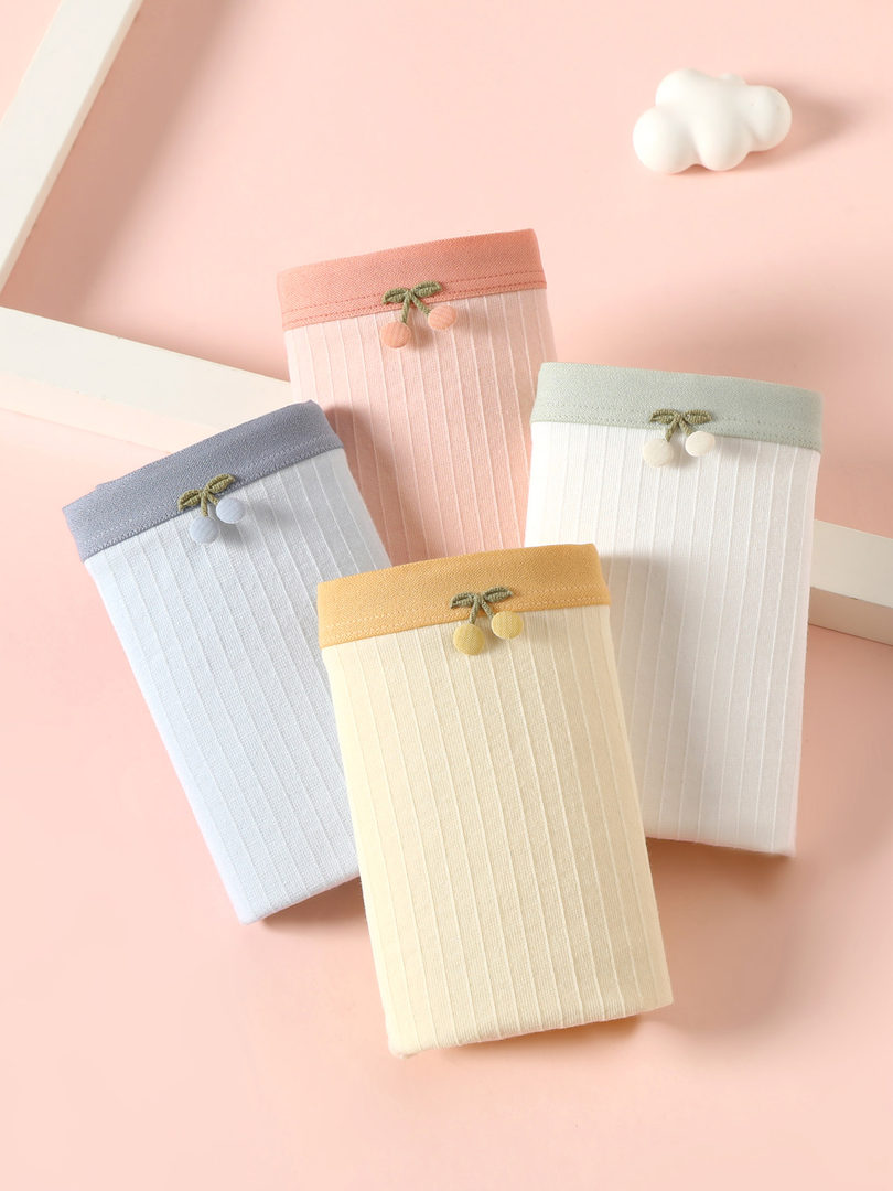 Pastel ribbed women's underwear or shorts laid flat on a pink background