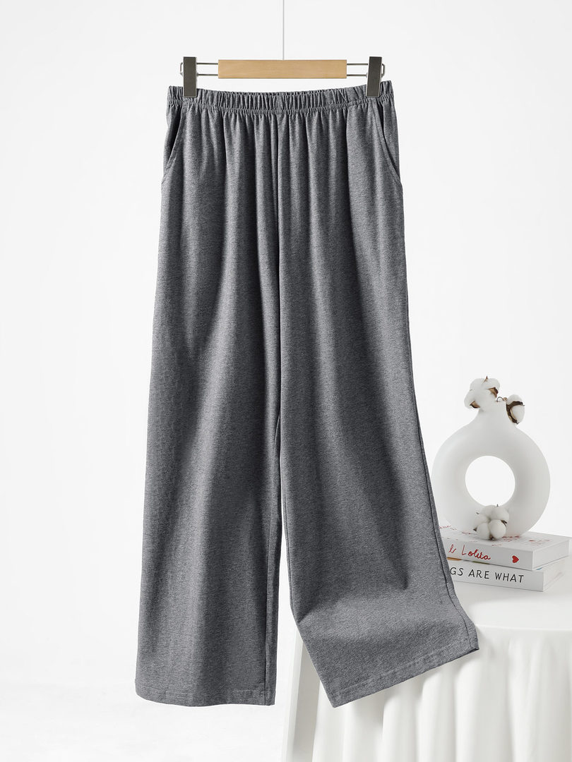 Gray wide-leg lounge pants hanging on a hanger against a white background