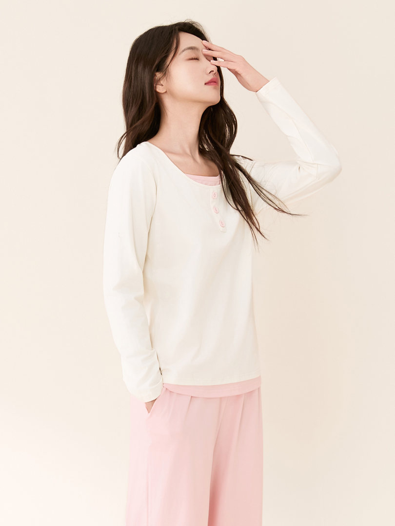 Model wearing a white long-sleeve top with pink lounge pants
