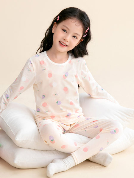 Child model wearing a pastel patterned long-sleeve pajama set