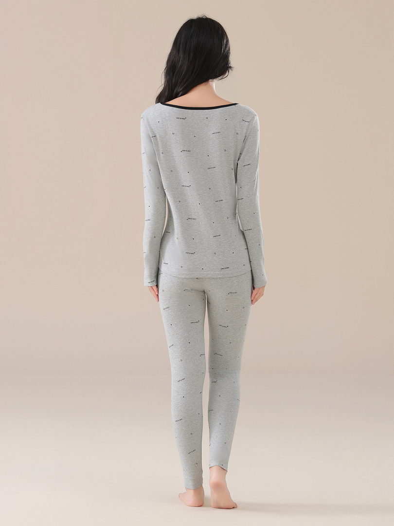 Model wearing a light gray long-sleeve top and matching leggings loungewear set
