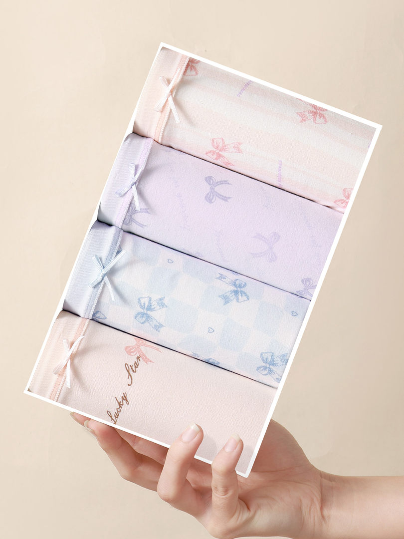 Pastel bow-print folded lingerie set displayed in a hand