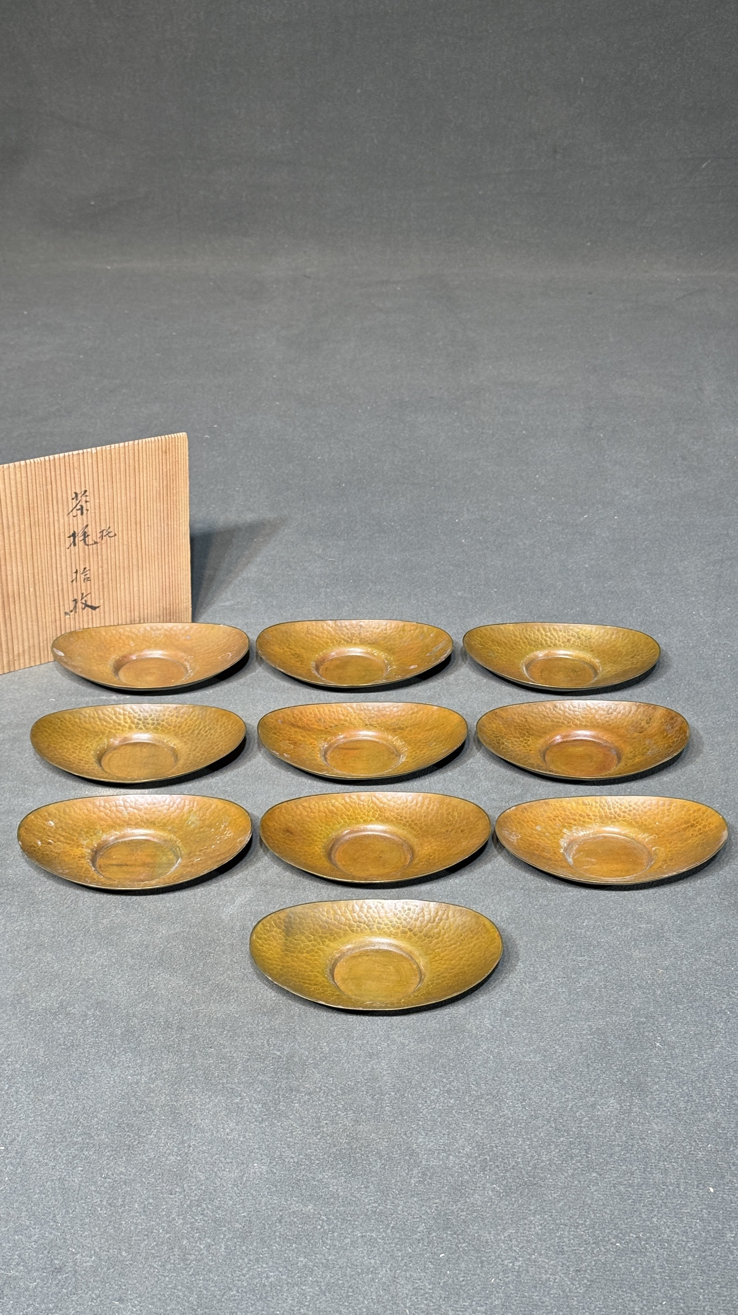 日本名堂口作锤纹老铜茶托十个，重780克，长12.5厘米，宽8.5厘米
