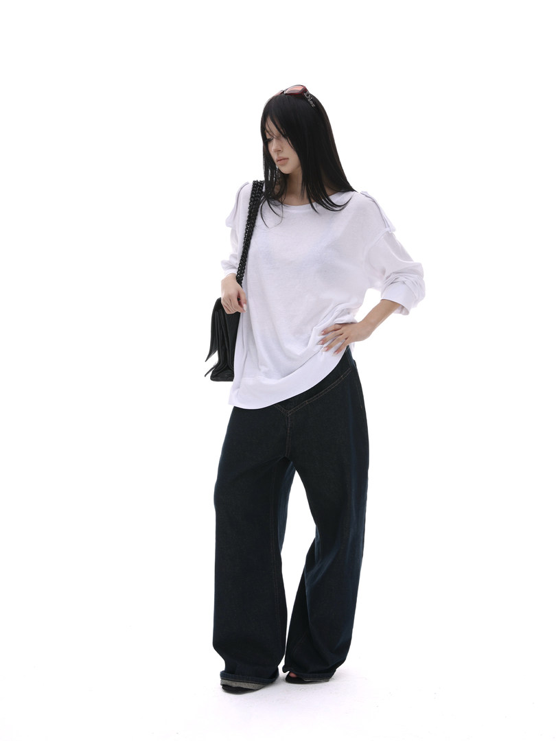 Model wearing a white oversized long-sleeve top with black wide-leg pants