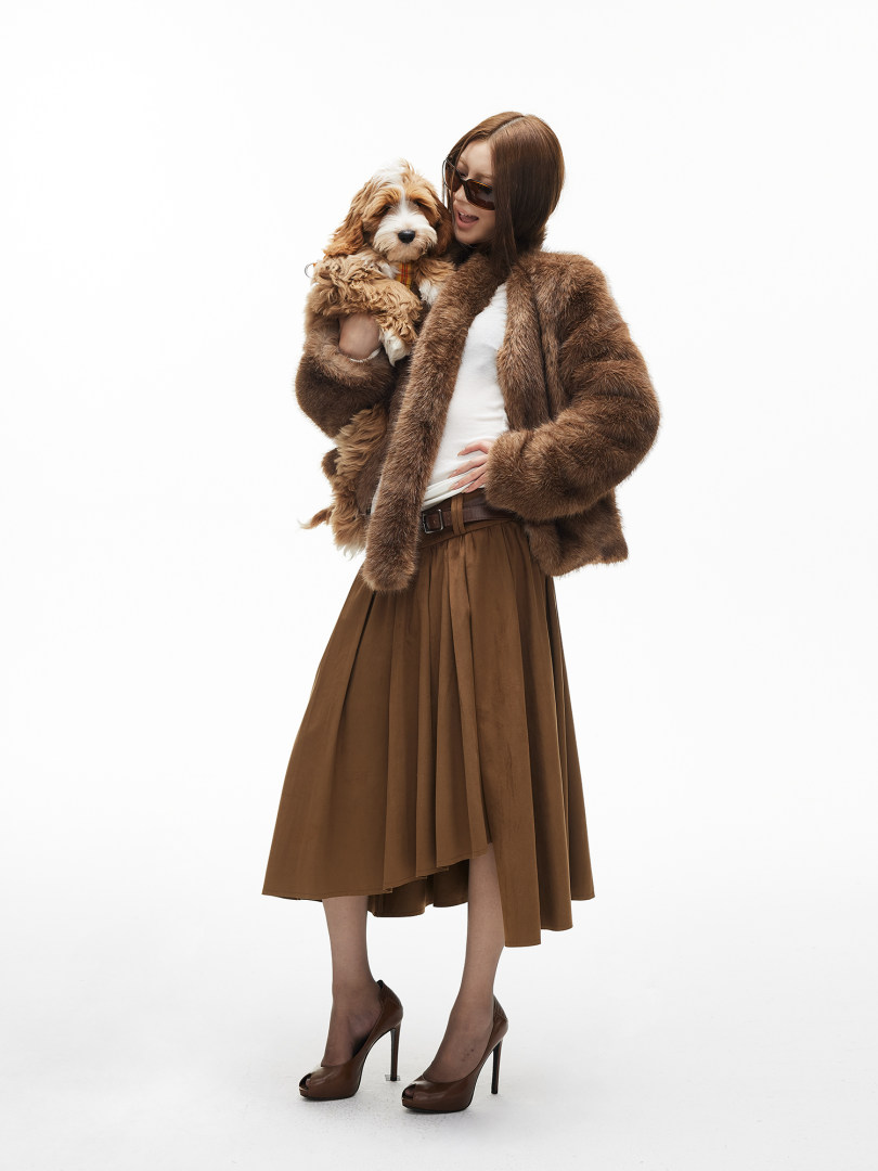 Woman modeling a brown faux fur jacket with a matching brown skirt and heels