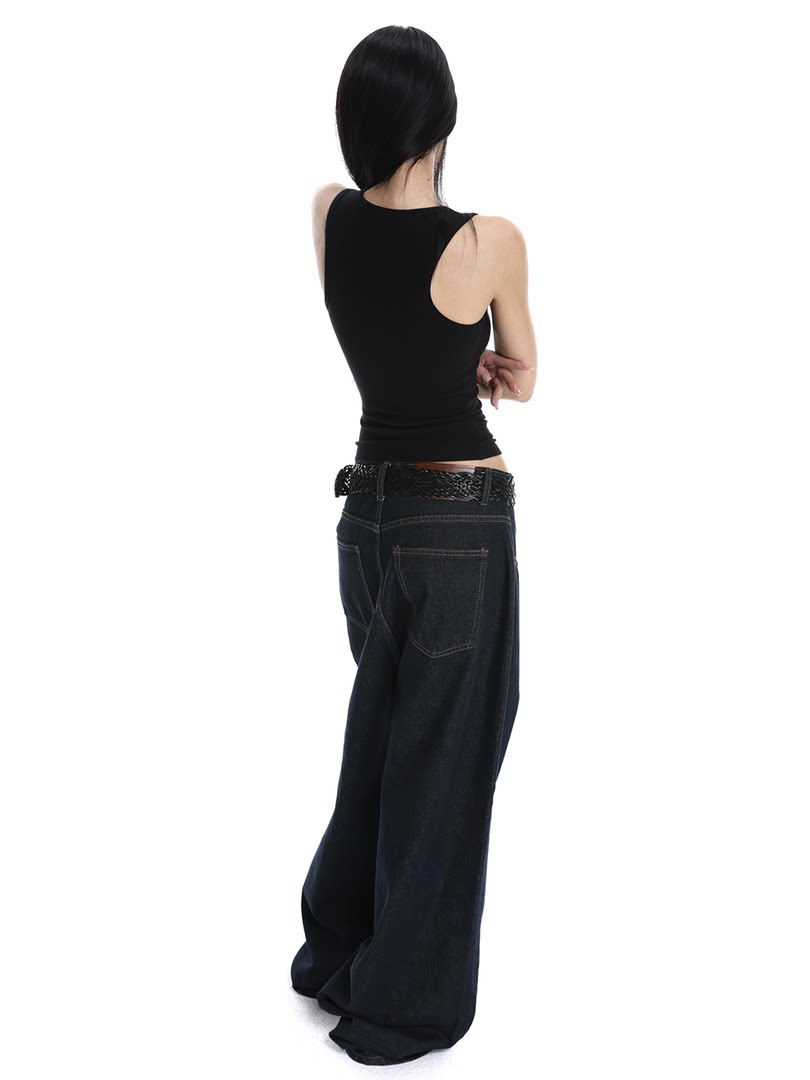 Model wearing a black sleeveless top with oversized dark wide-leg jeans