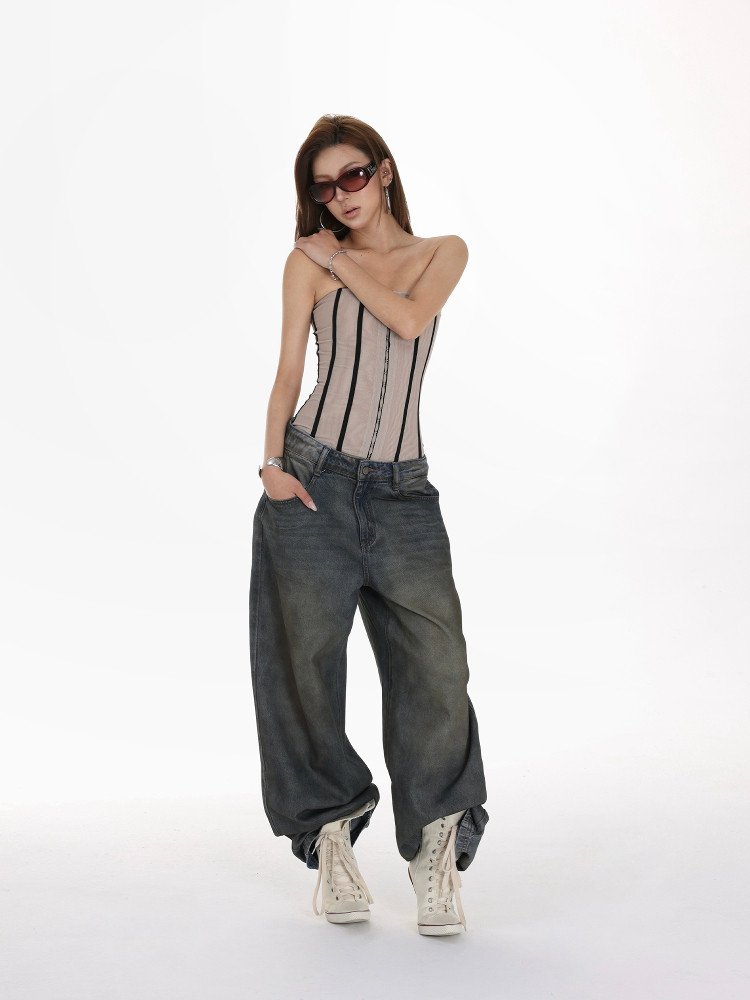 Model wearing a strapless corset top with baggy jeans and white boots