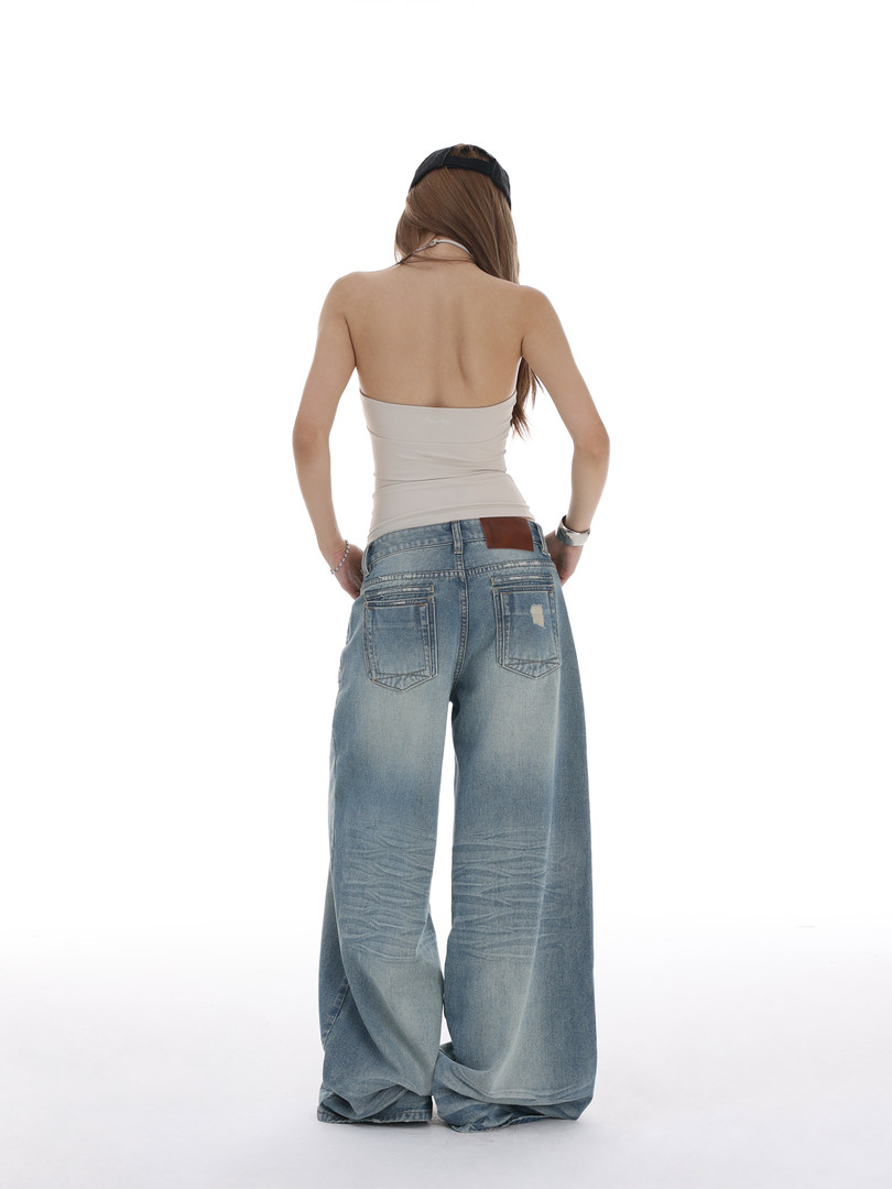 Model wearing oversized light-wash wide-leg denim jeans