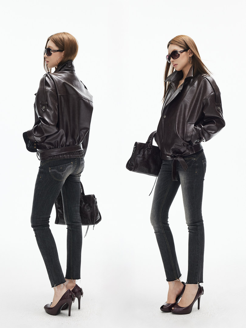 Fashion model wearing a dark leather jacket with skinny jeans and heels