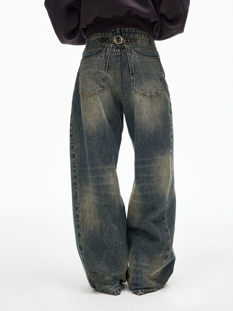 Wide-leg faded blue jeans worn by a model on a white background