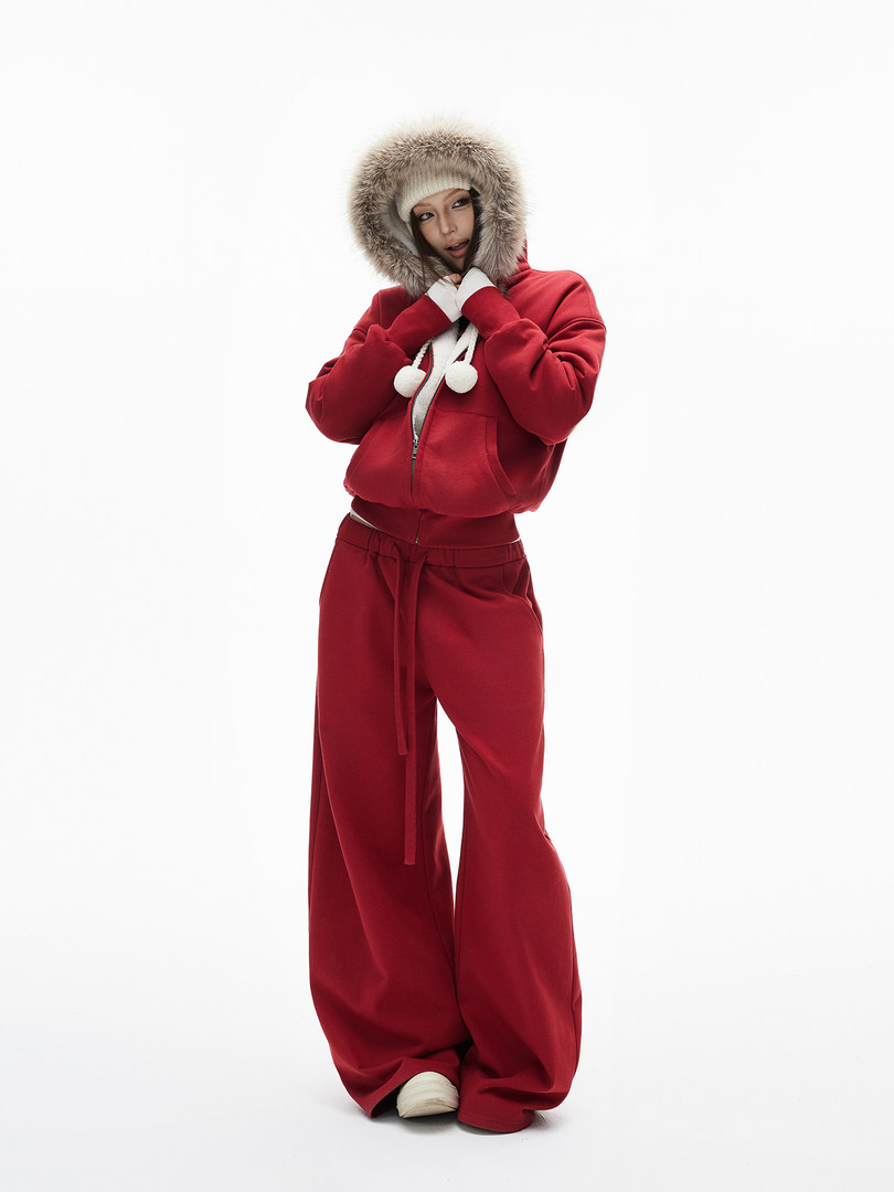 Model wearing a red hooded tracksuit with fur-trimmed hood