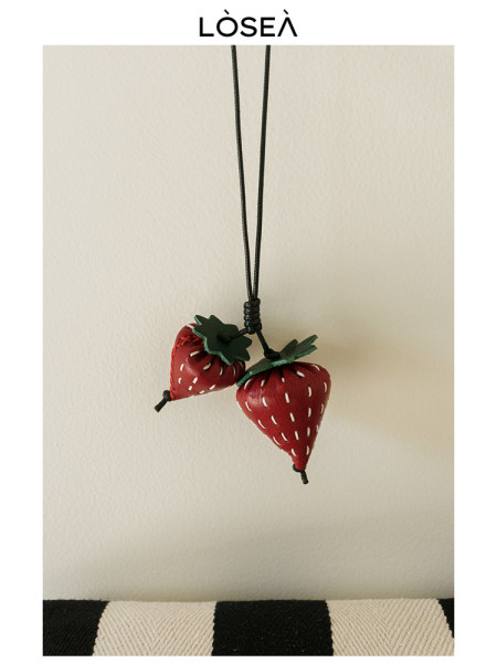 Strawberry pendant necklace with two red fruit charms on a black cord