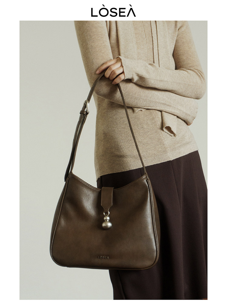 Brown leather shoulder handbag worn by a model