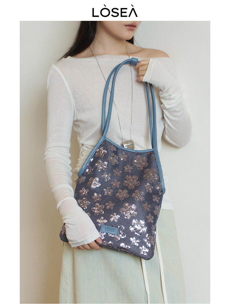 Blue sequined shoulder bag worn by a model