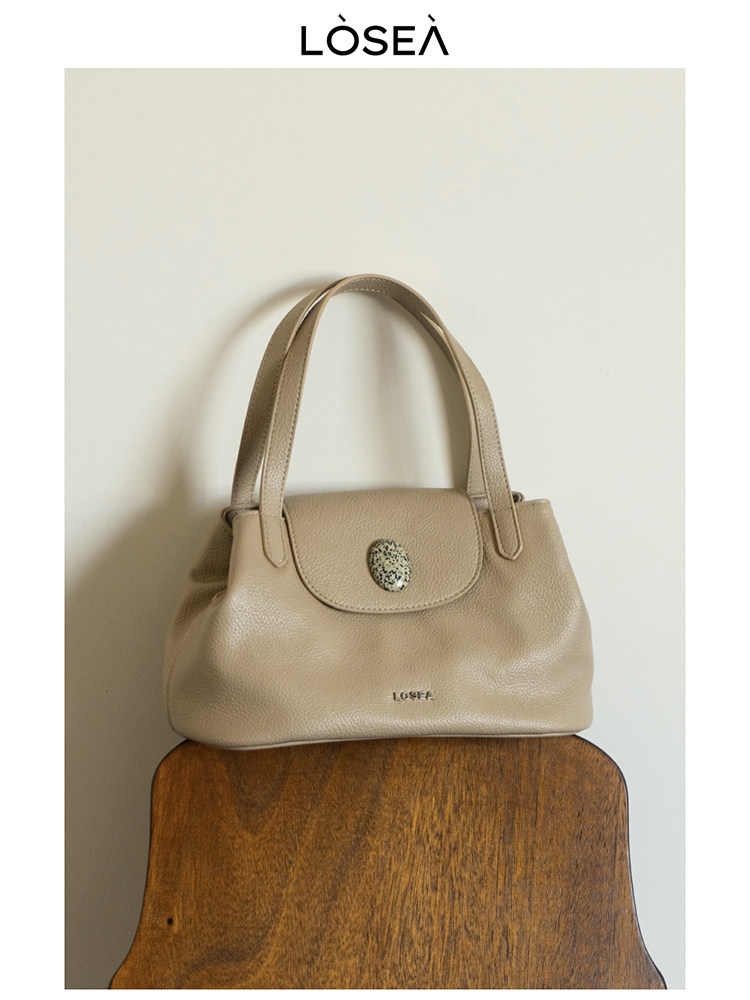 Beige leather handbag with top handles and flap closure