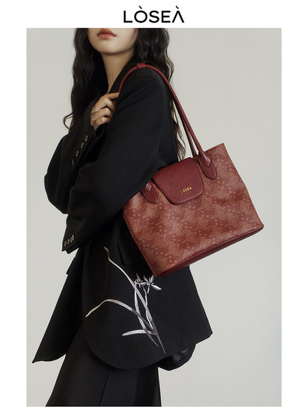 Red patterned tote handbag worn by a model