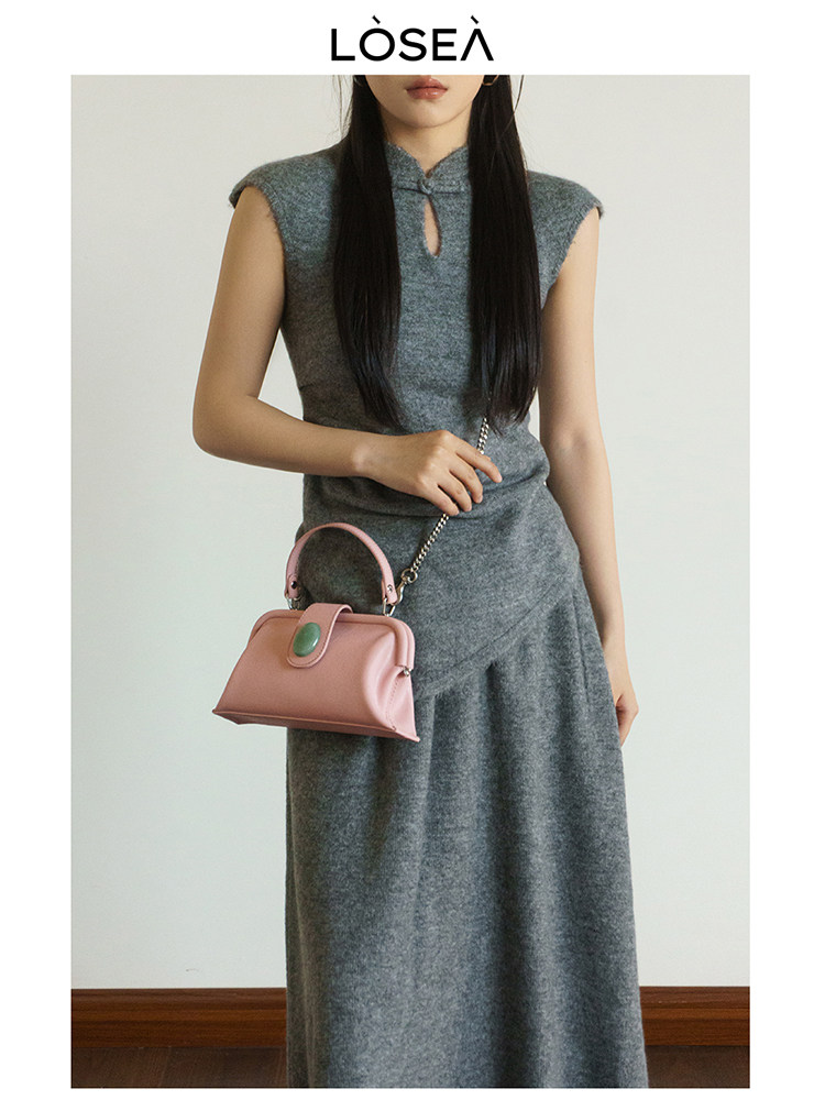 Model wearing a gray sleeveless knit midi dress with a pink handbag