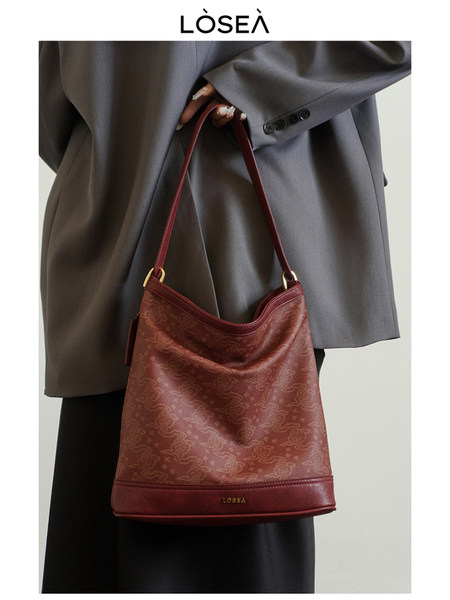 Burgundy shoulder handbag worn with a gray blazer