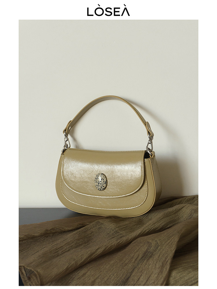 Tan leather shoulder handbag on a neutral background
