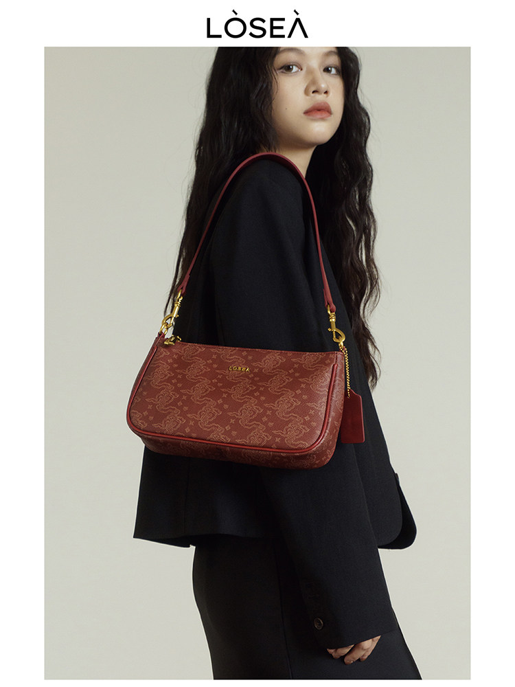 Red patterned shoulder handbag worn by a model