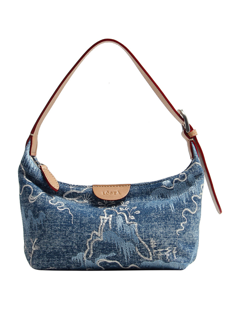 Blue denim shoulder handbag with patterned design and tan strap